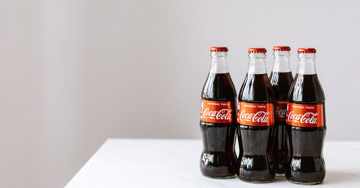 How will reducing and freezing affect the flavor of stock? - Curve shaped glass bottles of cold cola placed on white table against gray background How will reducing and freezing affect the flavor of stock? - Curve shaped glass bottles of cold cola placed on white table against gray background