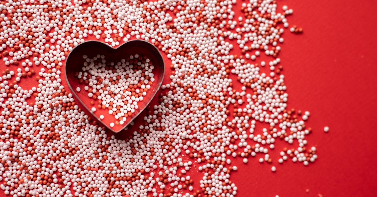 I love palm sugar, when can I bake with it - Top view of heart shaped form for baking among sweet sugar sprinkles scattered on red background as symbol of Saint Valentines Day I love palm sugar, when can I bake with it - Top view of heart shaped form for baking among sweet sugar sprinkles scattered on red background as symbol of Saint Valentines Day