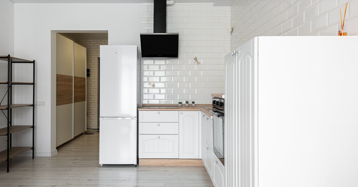 Ice-cream-on-a-stick in refrigerator temperature - Contemporary kitchen with refrigerator and hood against decorative white brick wall in house with empty shelves on parquet Ice-cream-on-a-stick in refrigerator temperature - Contemporary kitchen with refrigerator and hood against decorative white brick wall in house with empty shelves on parquet