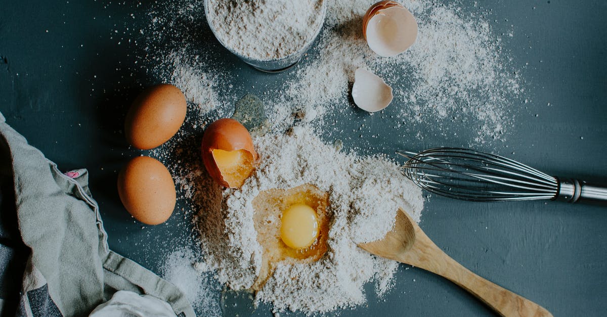 Identifying bulgur from cracked wheat - Flour and broken eggs on table before dough kneading Identifying bulgur from cracked wheat - Flour and broken eggs on table before dough kneading
