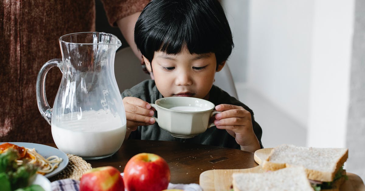 If evaporated milk is mixed with water, does it have the same calcium and vitamin D amounts as regular milk? - Asian boy drinking milk in kitchen If evaporated milk is mixed with water, does it have the same calcium and vitamin D amounts as regular milk? - Asian boy drinking milk in kitchen