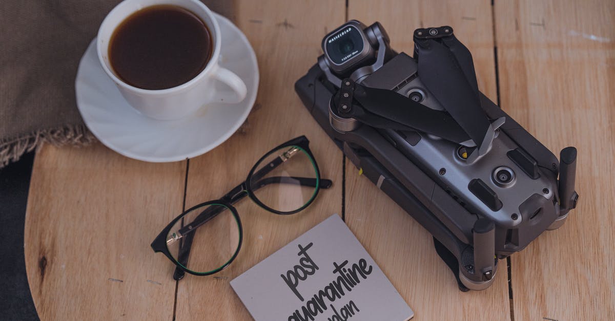 Impossible to manage sticky dough - From above of coffee cup and eyeglasses placed on wooden table near folded drone and sticky note with post quarantine plan inscription Impossible to manage sticky dough - From above of coffee cup and eyeglasses placed on wooden table near folded drone and sticky note with post quarantine plan inscription