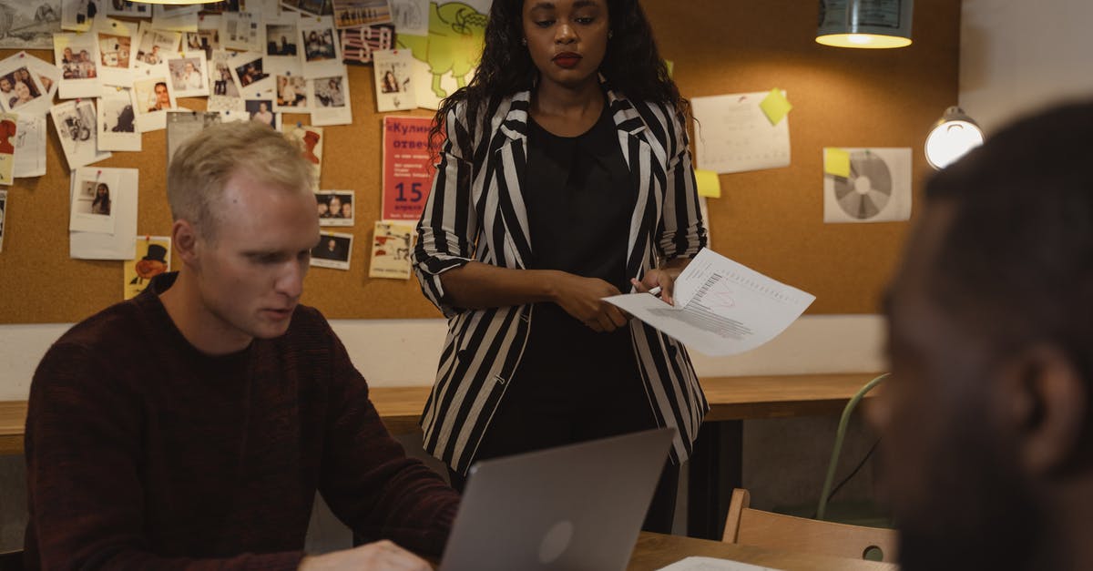 In what situation could we use black garlic? - Woman in Black and White Coat Standing Beside Man Sitting Using Laptop In what situation could we use black garlic? - Woman in Black and White Coat Standing Beside Man Sitting Using Laptop