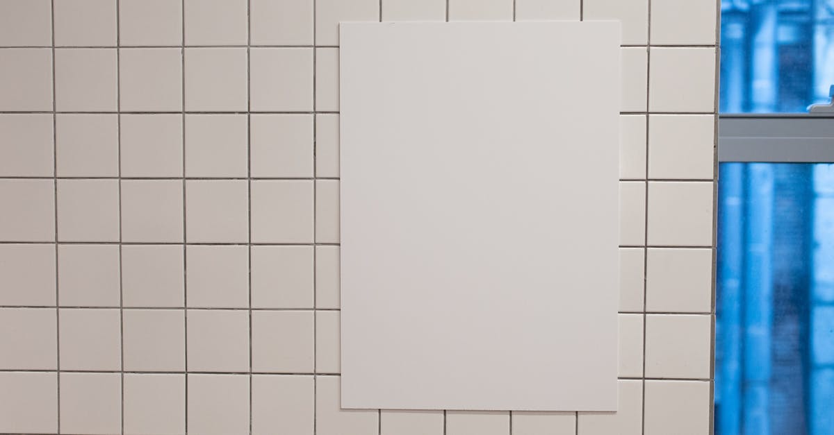 Info about spelt - Blank white placard hanging on wall covered with white tiles inside of building Info about spelt - Blank white placard hanging on wall covered with white tiles inside of building
