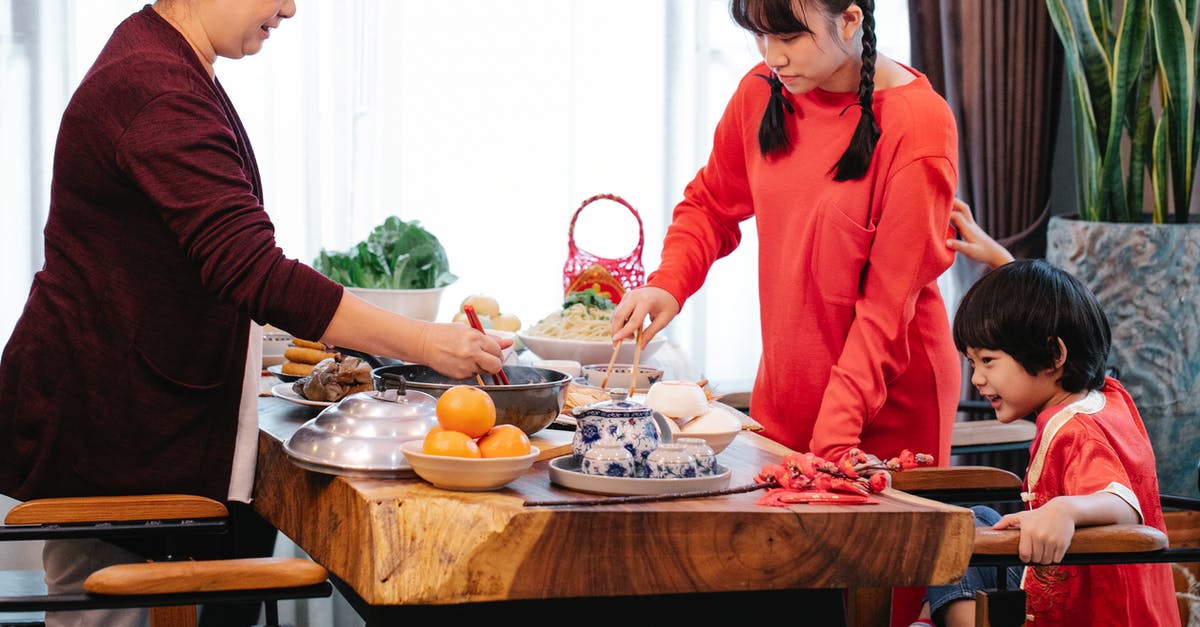Infusing orange into tea while avoiding bitterness - Crop smiling Asian grandmother with boy and teen serving food Infusing orange into tea while avoiding bitterness - Crop smiling Asian grandmother with boy and teen serving food