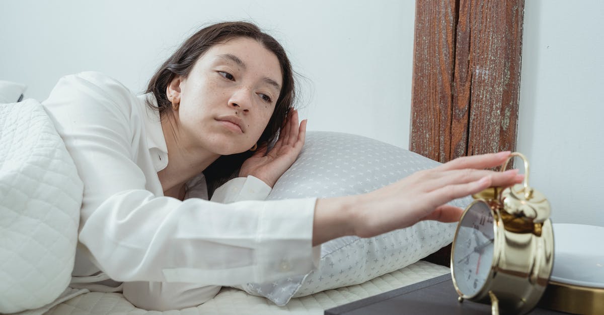 Inside of the cookies turn up soft, almost uncooked? - Sleepy young brunette female in white sleepwear resting in comfortable bed and waking up with alarm clock at home in morning time Inside of the cookies turn up soft, almost uncooked? - Sleepy young brunette female in white sleepwear resting in comfortable bed and waking up with alarm clock at home in morning time