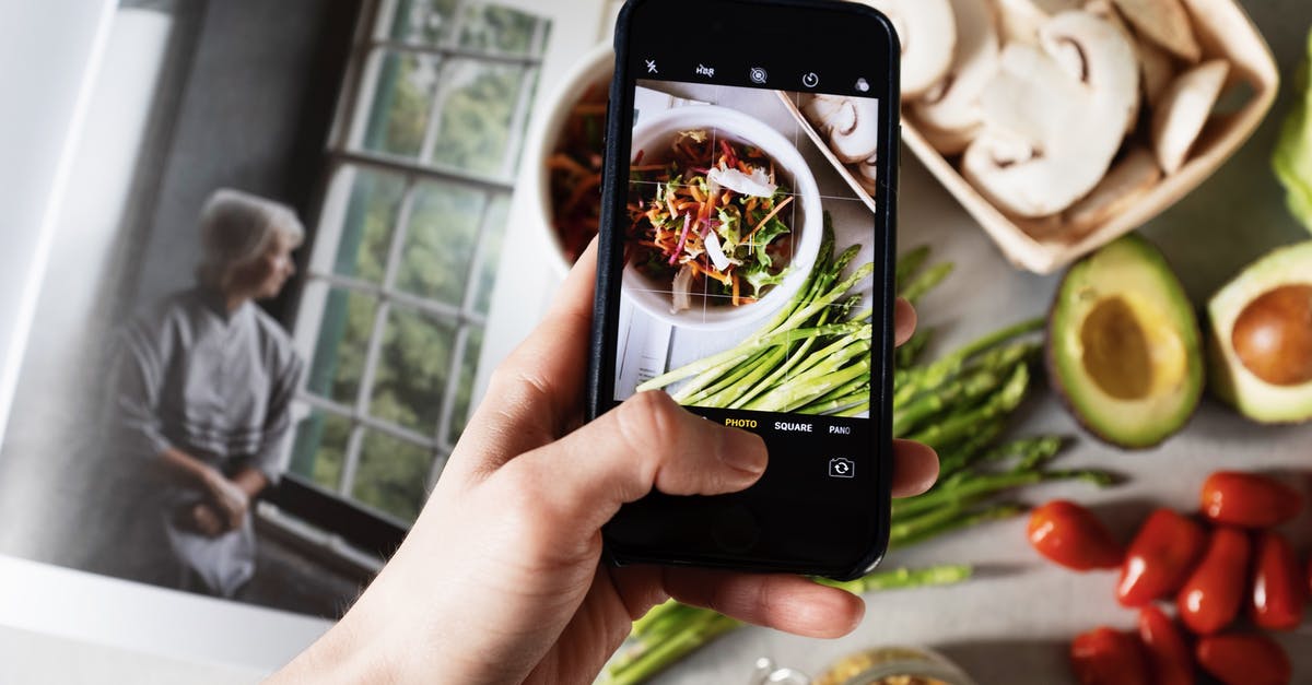 Interesting use for Okra as the main ingredient in a dish? - From above view of faceless blogger taking photo on smartphone of fresh tasty salad in white bowl and food placed around on table in modern kitchen Interesting use for Okra as the main ingredient in a dish? - From above view of faceless blogger taking photo on smartphone of fresh tasty salad in white bowl and food placed around on table in modern kitchen