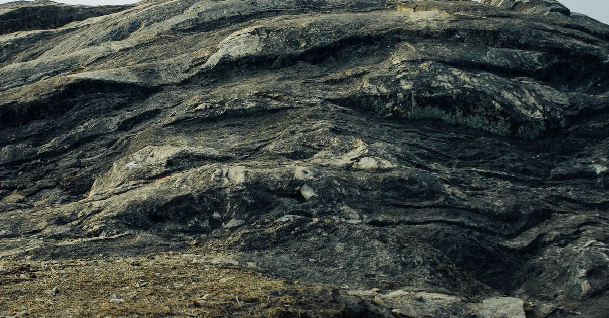 intermittent solid crust on top of yogurt - Low angle of huge hard stone formation with uneven surface located in nature intermittent solid crust on top of yogurt - Low angle of huge hard stone formation with uneven surface located in nature