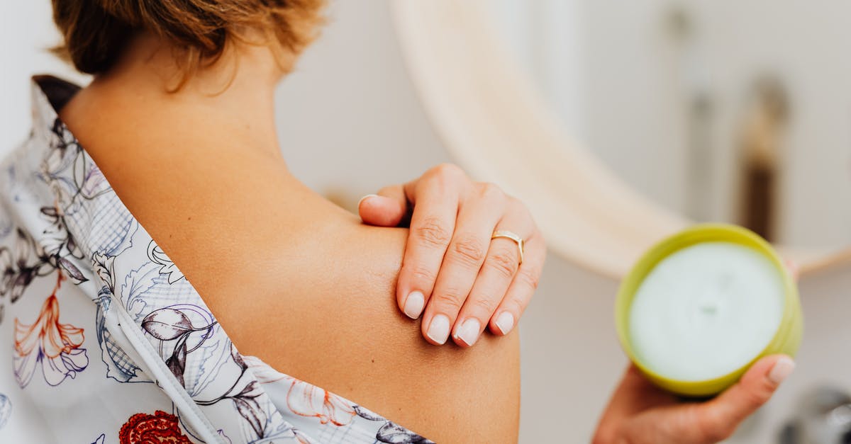Irish Cream Manufacturing - Woman Putting Cream on Shoulder Irish Cream Manufacturing - Woman Putting Cream on Shoulder