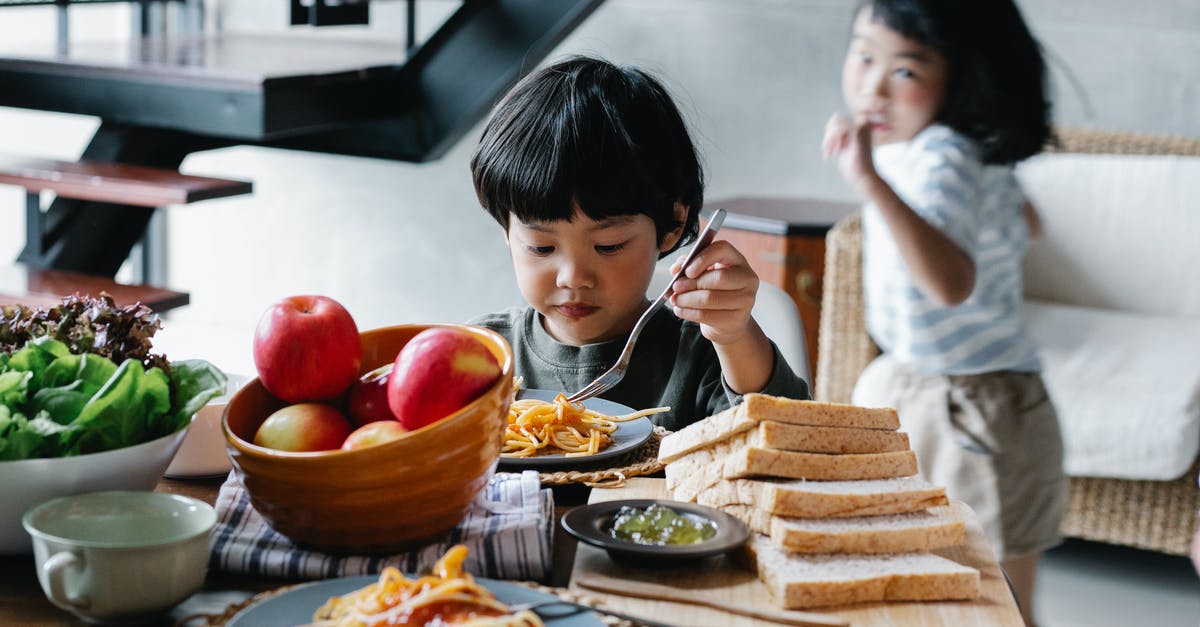 Is active dry yeast safe to eat as-is? - Active little Asian girl running behind brother having lunch in kitchen Is active dry yeast safe to eat as-is? - Active little Asian girl running behind brother having lunch in kitchen
