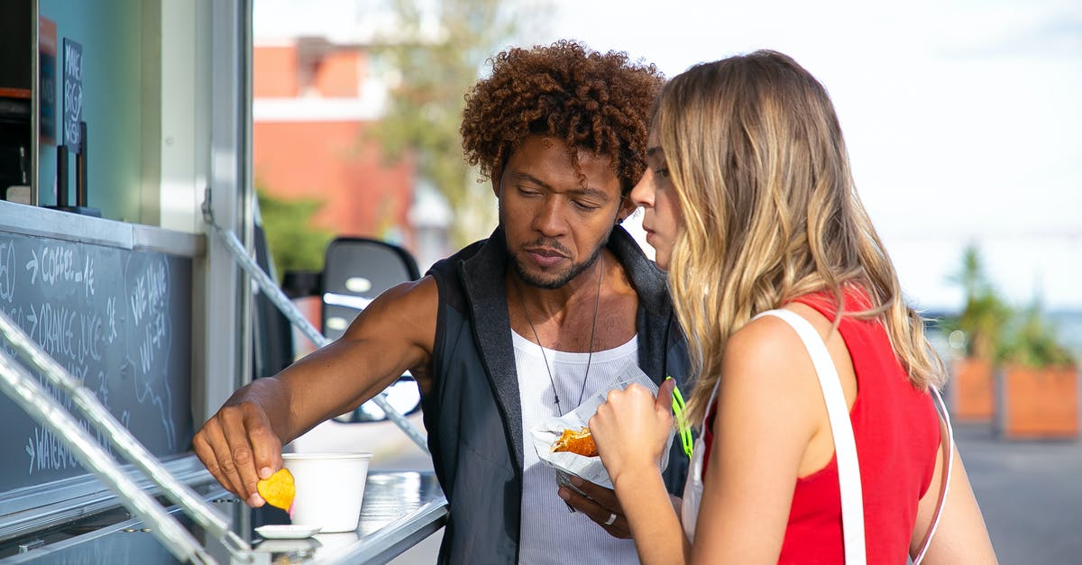 is frozen hamburger ok to eat after the sell by date? [duplicate] - Hungry young black man and woman in casual clothes eating yummy crisps with sauce and hamburger while having lunch in food truck