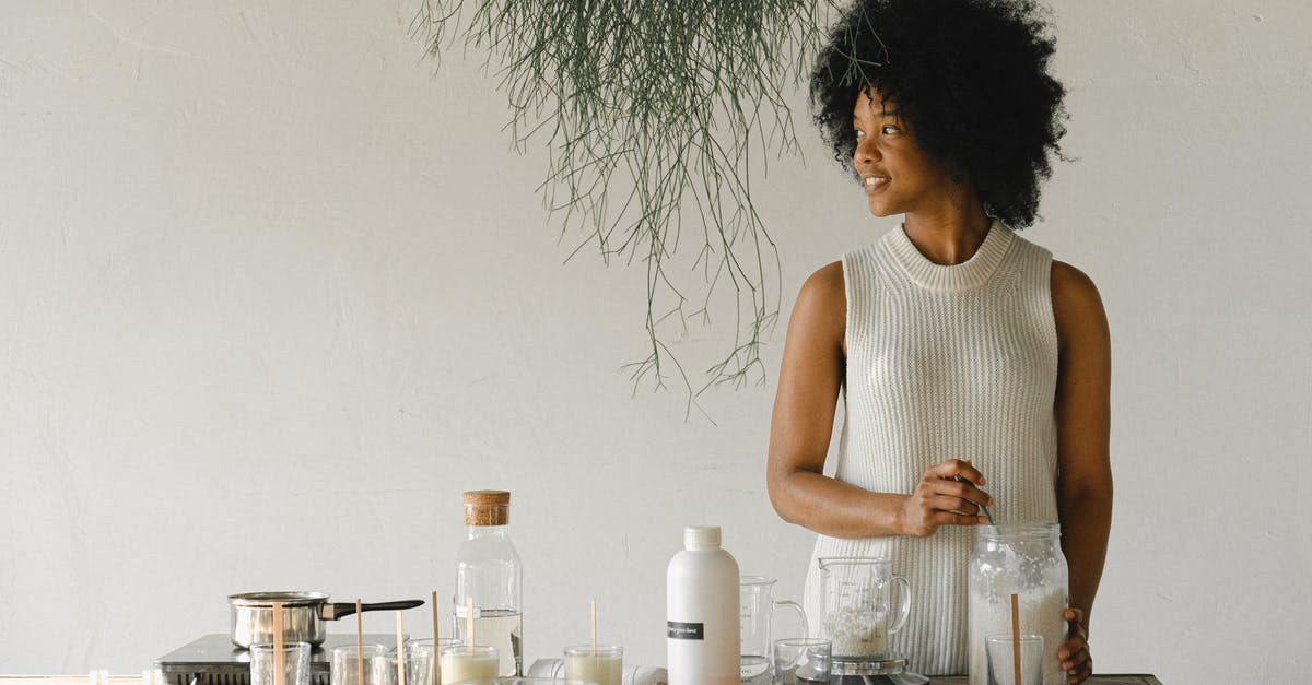 Is it a mold in my scoby? - Content African American female artisan with jar of wax flakes looking away while creating candles in modern workshop in light room
