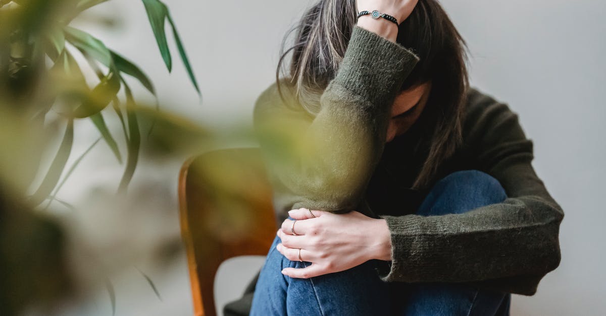 Is it a problem that the same flipper that touched raw blood touches the finished meat? [duplicate] - Anonymous young sorrowed female in casual outfit touching dark hair and embracing knees while sitting on chair at home