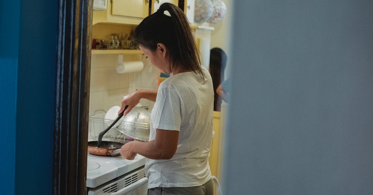 Is it common for slow cookers to heat unevenly? - Woman cooking lunch in light kitchen Is it common for slow cookers to heat unevenly? - Woman cooking lunch in light kitchen