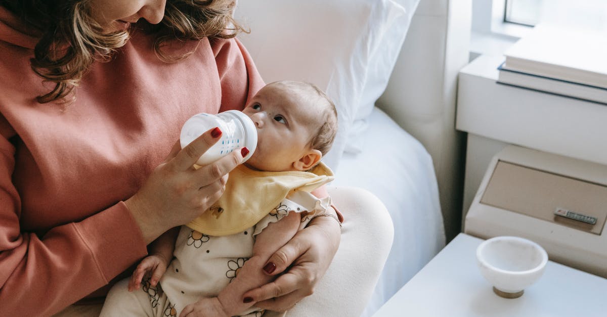 Is it okay to feed milk powder to sourdough starter? - From above of crop happy young mother in casual clothes smiling while hugging and feeding adorable newborn from bottle sitting on comfortable bed Is it okay to feed milk powder to sourdough starter? - From above of crop happy young mother in casual clothes smiling while hugging and feeding adorable newborn from bottle sitting on comfortable bed
