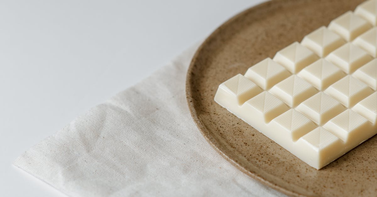 Is it possible to temper chocolate at home? - Delicious white chocolate on ceramic plate Is it possible to temper chocolate at home? - Delicious white chocolate on ceramic plate