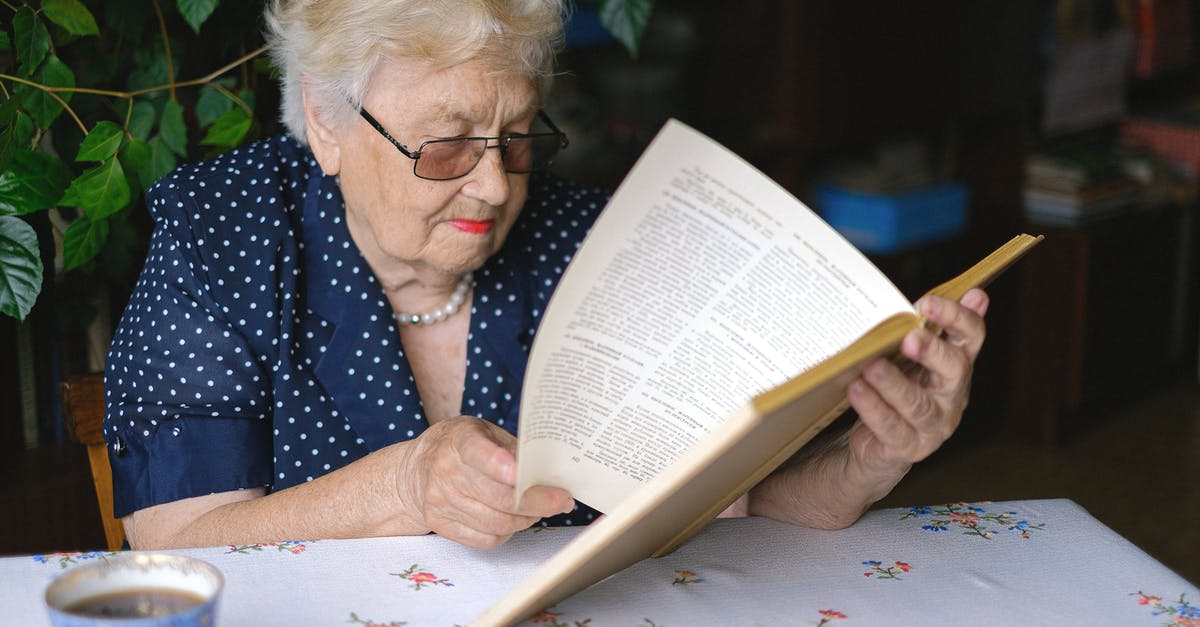 Is it possible to turn old tomatoes into flour? - Focused aged woman turning pages of book Is it possible to turn old tomatoes into flour? - Focused aged woman turning pages of book