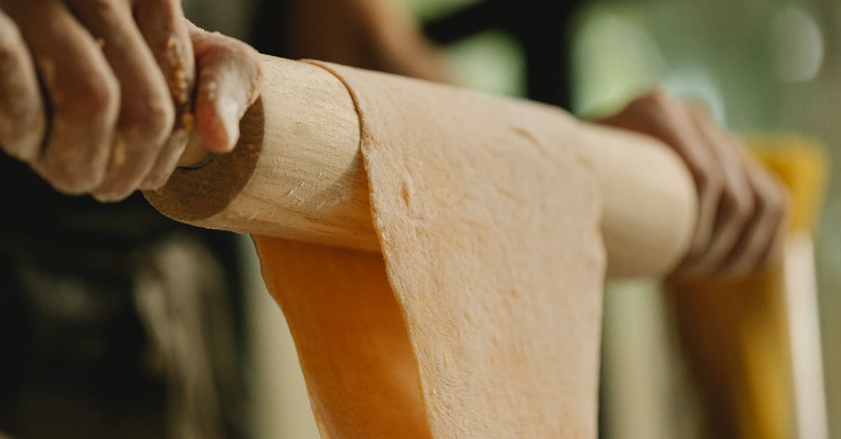 Is it possible to use casserole dish to make no-knead bread? - Low angle of unrecognizable person stretching soft dough on rolling pin while preparing food in kitchen Is it possible to use casserole dish to make no-knead bread? - Low angle of unrecognizable person stretching soft dough on rolling pin while preparing food in kitchen