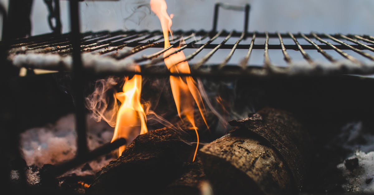 Is it possible to use wood chips on an electric grill to get a more smoky flavour? - Burning Under Black Metal Grill Is it possible to use wood chips on an electric grill to get a more smoky flavour? - Burning Under Black Metal Grill