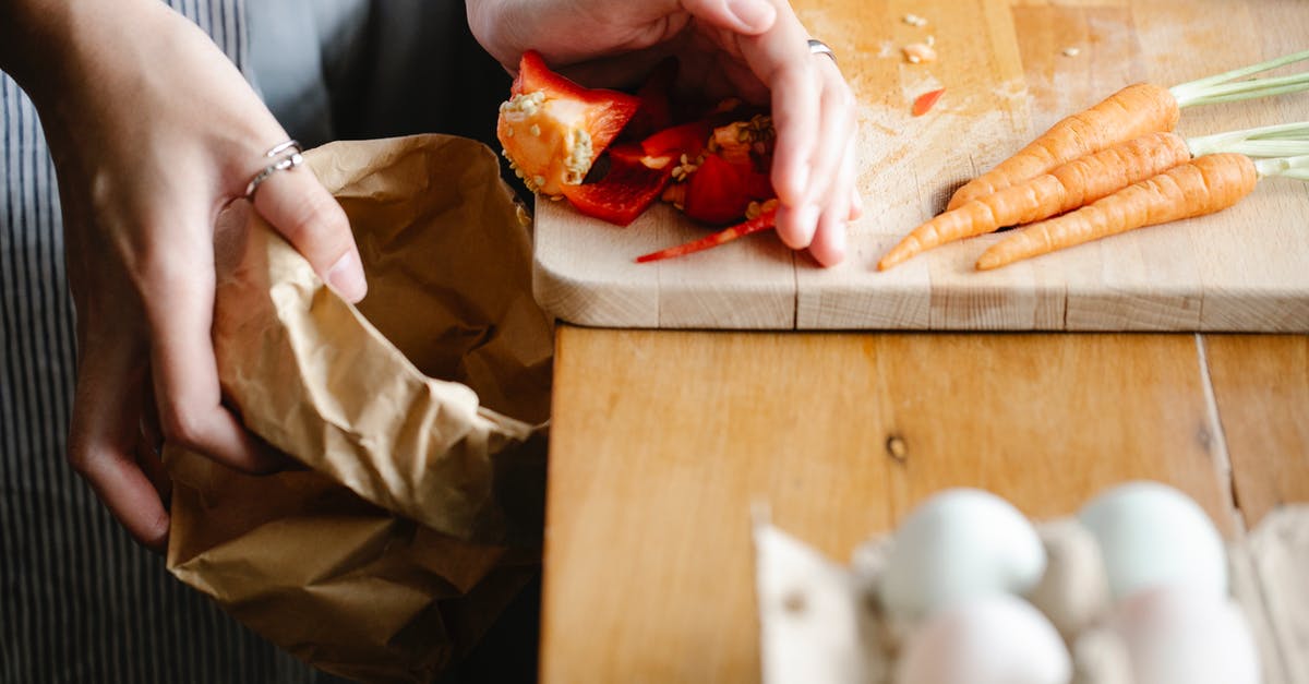 Is it safe to cook pork chops that thawed on counter overnight? [duplicate] - Unrecognizable female putting seeds of red bell pepper from cutting board into carton package while cooking at counter with carrots and eggs