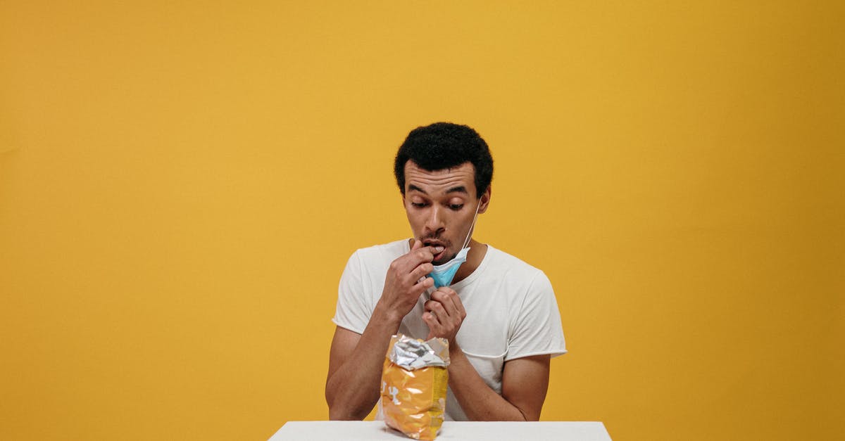 Is it safe to eat off of partially tarnished silver? - Man in White Crew Neck T-shirt Eating Chips Is it safe to eat off of partially tarnished silver? - Man in White Crew Neck T-shirt Eating Chips