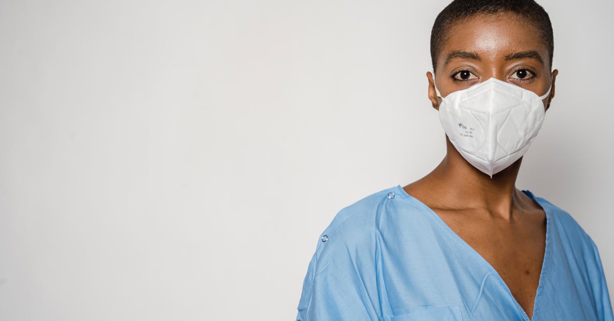 Is it safe to eat white rice that turned blue/purple in the fridge? - Serious African American female doctor in medical mask and blue uniform standing against white background Is it safe to eat white rice that turned blue/purple in the fridge? - Serious African American female doctor in medical mask and blue uniform standing against white background
