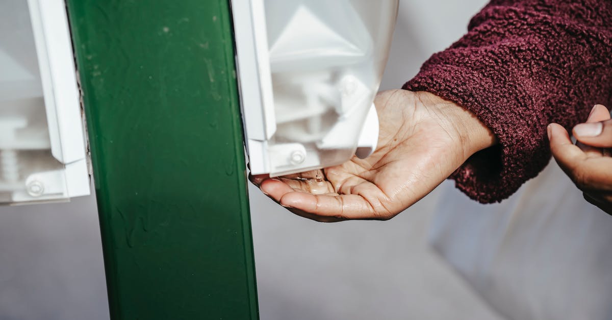 Is it safe to not wash mushrooms? - Crop anonymous black female in warm coat standing in street and using sanitizer in daylight Is it safe to not wash mushrooms? - Crop anonymous black female in warm coat standing in street and using sanitizer in daylight