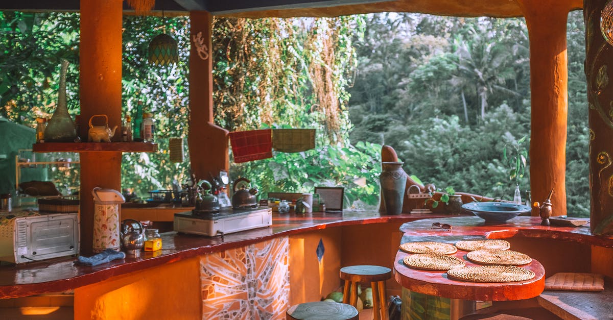 Is it safe to reheat old water in an electric kettle? - Table and stools in empty kitchen with portable stove and decorative lamps against green trees in summer Is it safe to reheat old water in an electric kettle? - Table and stools in empty kitchen with portable stove and decorative lamps against green trees in summer