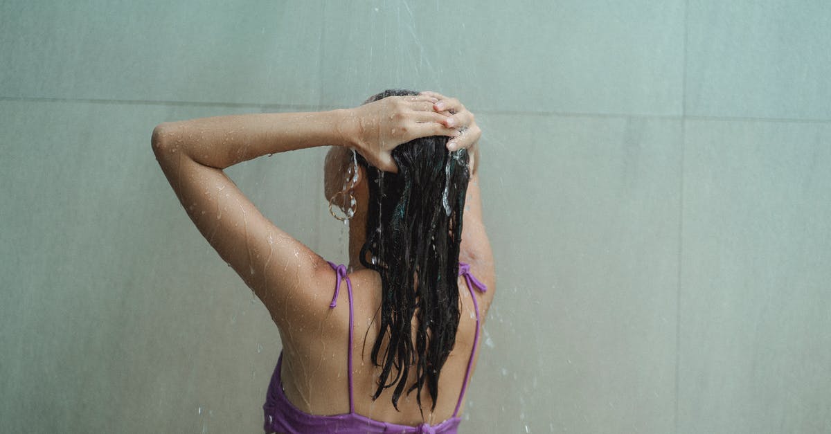 Is it sufficient to wash utensils, which have touched chicken, with soapy water - Slim woman in bikini washing head in spacious bathroom
