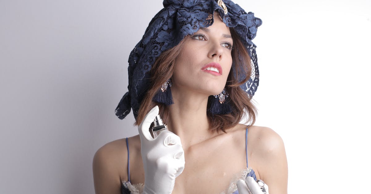 Is it true that smell is lost flavor? - Charismatic sensual female in elegant vintage blue dress and lace headgear wearing white satin gloves and luxury bijouterie looking away and spraying fragrant perfume to delicate neck skin against white background Is it true that smell is lost flavor? - Charismatic sensual female in elegant vintage blue dress and lace headgear wearing white satin gloves and luxury bijouterie looking away and spraying fragrant perfume to delicate neck skin against white background