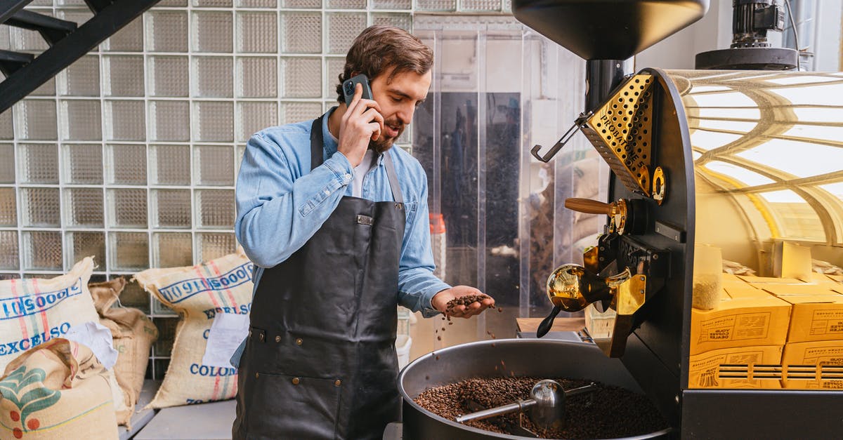 Is it worth checking beans for stones? - Man in Blue Dress Shirt Holding Black Smartphone Is it worth checking beans for stones? - Man in Blue Dress Shirt Holding Black Smartphone