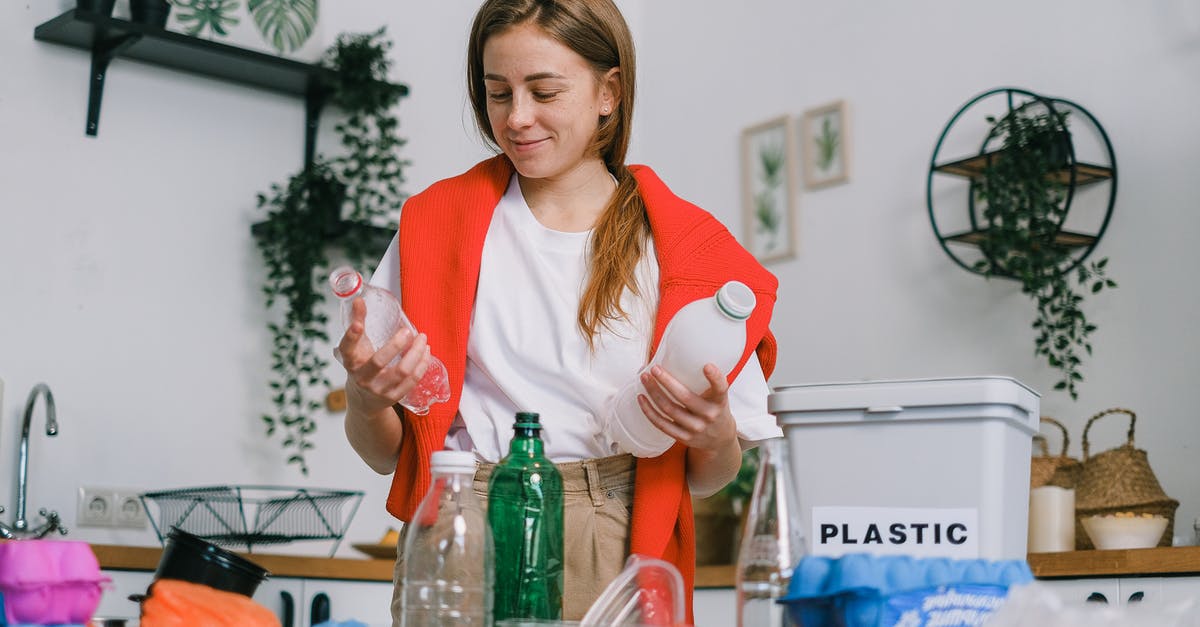 Is my pressure cooker good for the trash bin? - Cheerful female in casual clothes standing with plastic bottles in hands while sorting trash in light kitchen in daytime Is my pressure cooker good for the trash bin? - Cheerful female in casual clothes standing with plastic bottles in hands while sorting trash in light kitchen in daytime