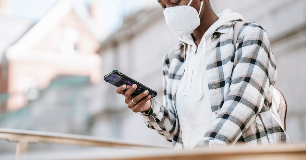 Is nonstick cookware safe to use after overheating - Black woman using smartphone on city street Is nonstick cookware safe to use after overheating - Black woman using smartphone on city street