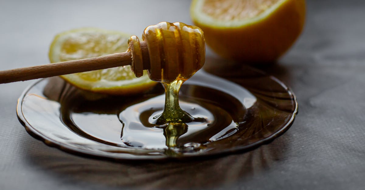 Is raw honey safe to consume? - Honey dipper above saucer with lemon Is raw honey safe to consume? - Honey dipper above saucer with lemon