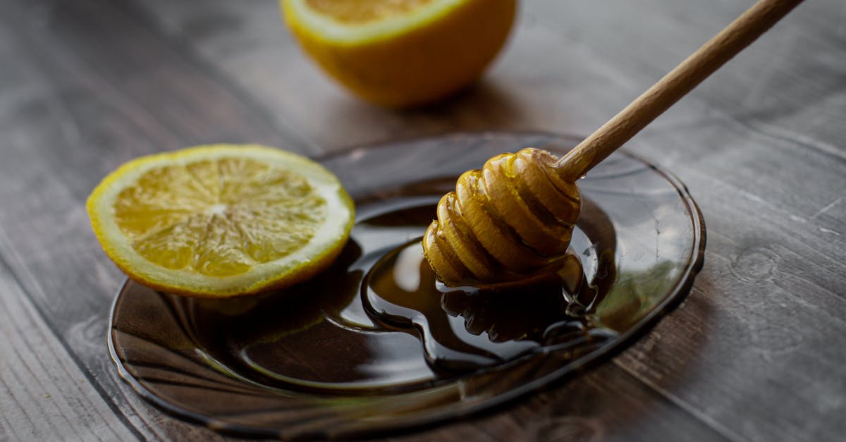 Is raw honey safe to consume? - Honey dipper placed on saucer with lemon slice Is raw honey safe to consume? - Honey dipper placed on saucer with lemon slice