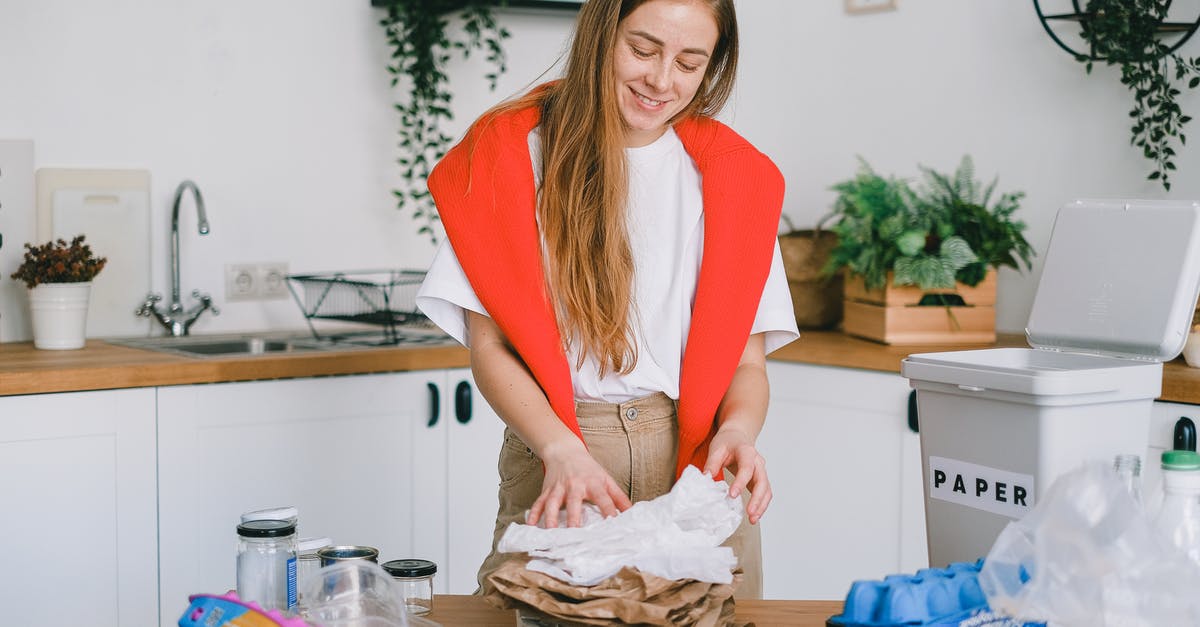 Is safe to reuse plastic bags used for sous vide - Smiling woman stacking paper litter for reuse Is safe to reuse plastic bags used for sous vide - Smiling woman stacking paper litter for reuse