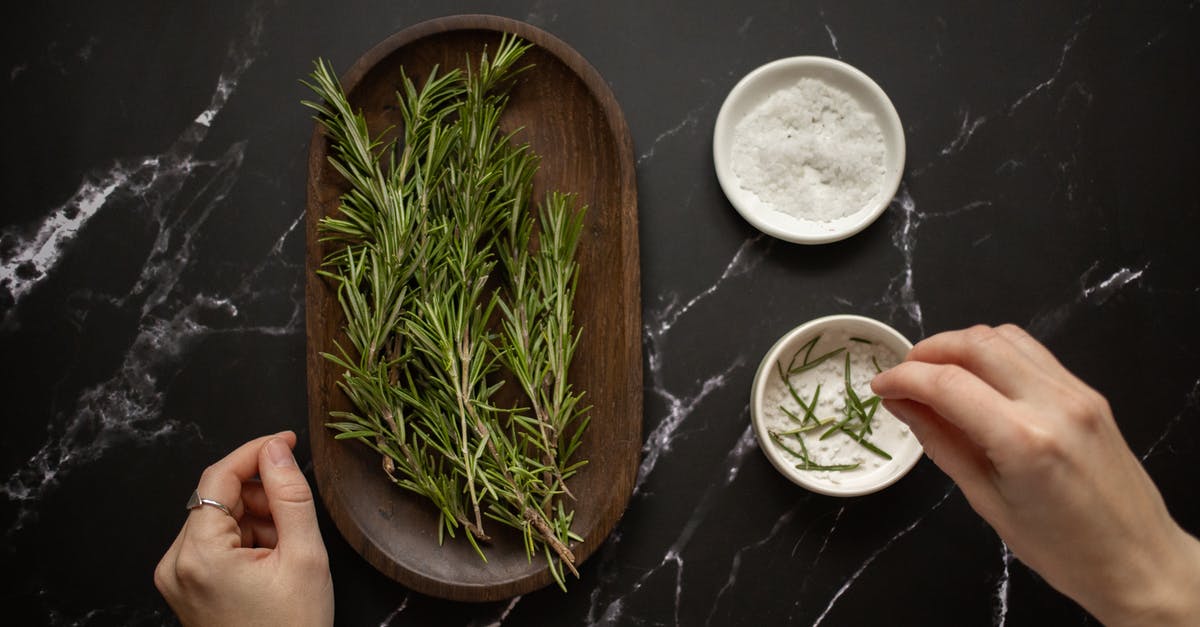 Is salt related to smell? - Top view of unrecognizable woman adding fresh twigs of rosemary in bowl with salt for organic scrub placed on black marble table Is salt related to smell? - Top view of unrecognizable woman adding fresh twigs of rosemary in bowl with salt for organic scrub placed on black marble table