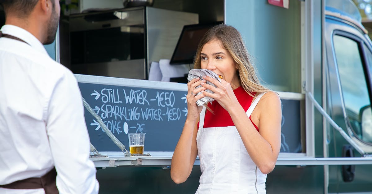 Is there a difference in taste between female and male beef? - Calm woman in stylish clothes standing near food truck and eating tasty burger on street in daytime Is there a difference in taste between female and male beef? - Calm woman in stylish clothes standing near food truck and eating tasty burger on street in daytime