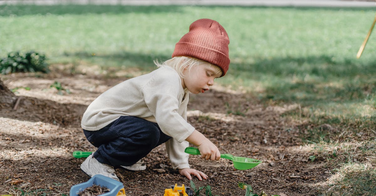 Is there a reason to have a plastic bowl? - Side view of little boy in casual clothes and brown hat playing with plastic toys in backyard Is there a reason to have a plastic bowl? - Side view of little boy in casual clothes and brown hat playing with plastic toys in backyard