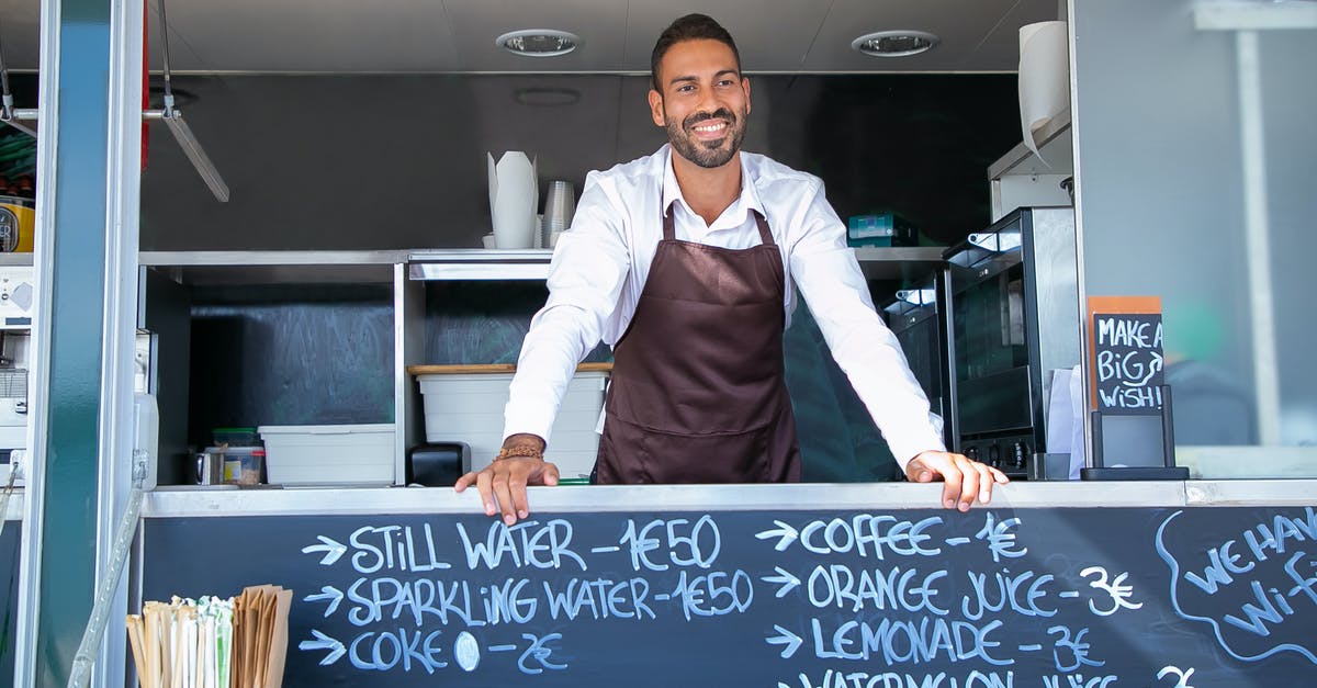Is there a resource on food prep times for labor costing? - Low angle of ethnic seller wearing uniform standing at counter in food trailer and smiling happily Is there a resource on food prep times for labor costing? - Low angle of ethnic seller wearing uniform standing at counter in food trailer and smiling happily