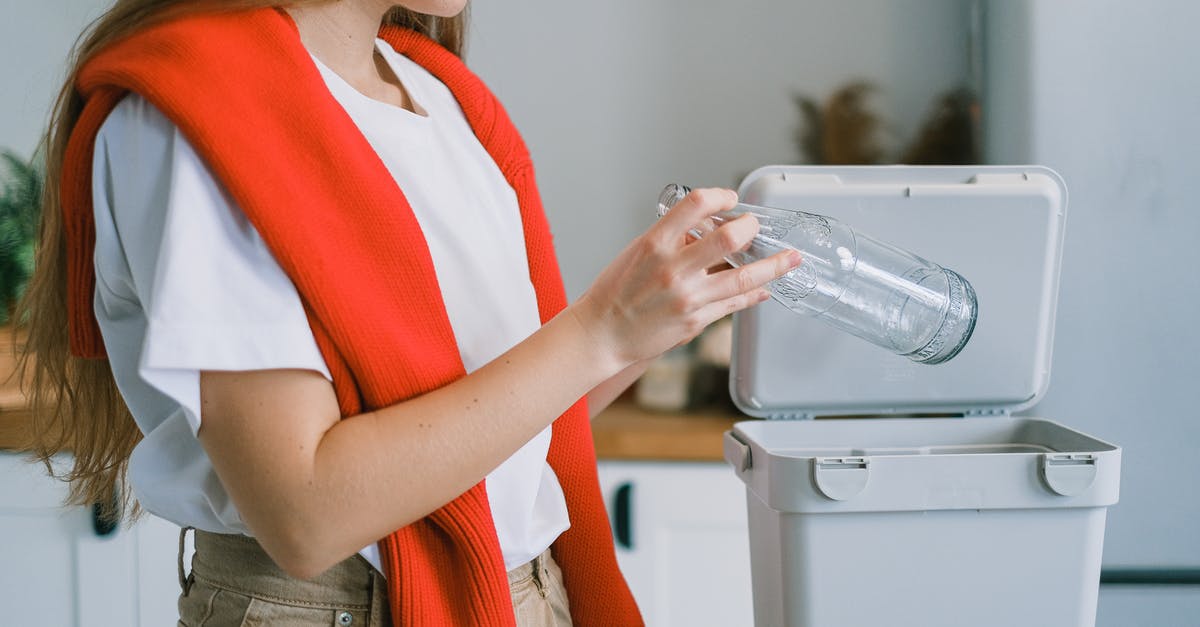 Is there a safe way to remove items that have fallen into a Garbage Disposal? - Crop anonymous female in casual clothes utilizing empty glass bottle into rubbish bin while cleaning kitchen and sorting out rubbish at home Is there a safe way to remove items that have fallen into a Garbage Disposal? - Crop anonymous female in casual clothes utilizing empty glass bottle into rubbish bin while cleaning kitchen and sorting out rubbish at home