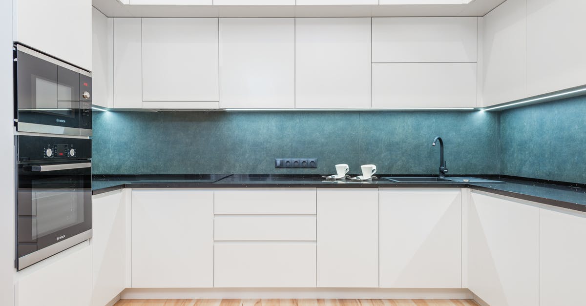 Is there a technique to making Caramel in a Microwave oven? - Interior of white modern kitchen with minimalist design of white cabinets blue backsplash and black built in appliances Is there a technique to making Caramel in a Microwave oven? - Interior of white modern kitchen with minimalist design of white cabinets blue backsplash and black built in appliances