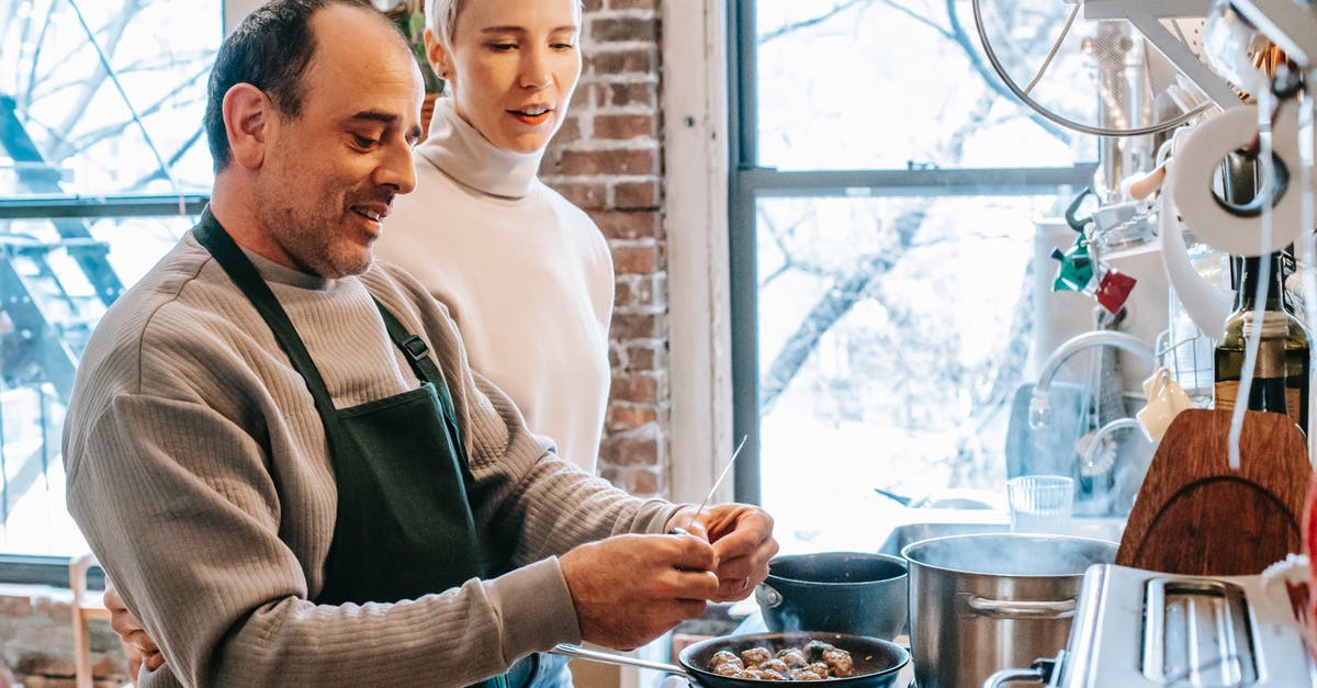 Is there an aging process by which to "oak" meat? - Smiling man in apron cooking against attentive girlfriend and gas stove with meatballs in pan at home Is there an aging process by which to "oak" meat? - Smiling man in apron cooking against attentive girlfriend and gas stove with meatballs in pan at home