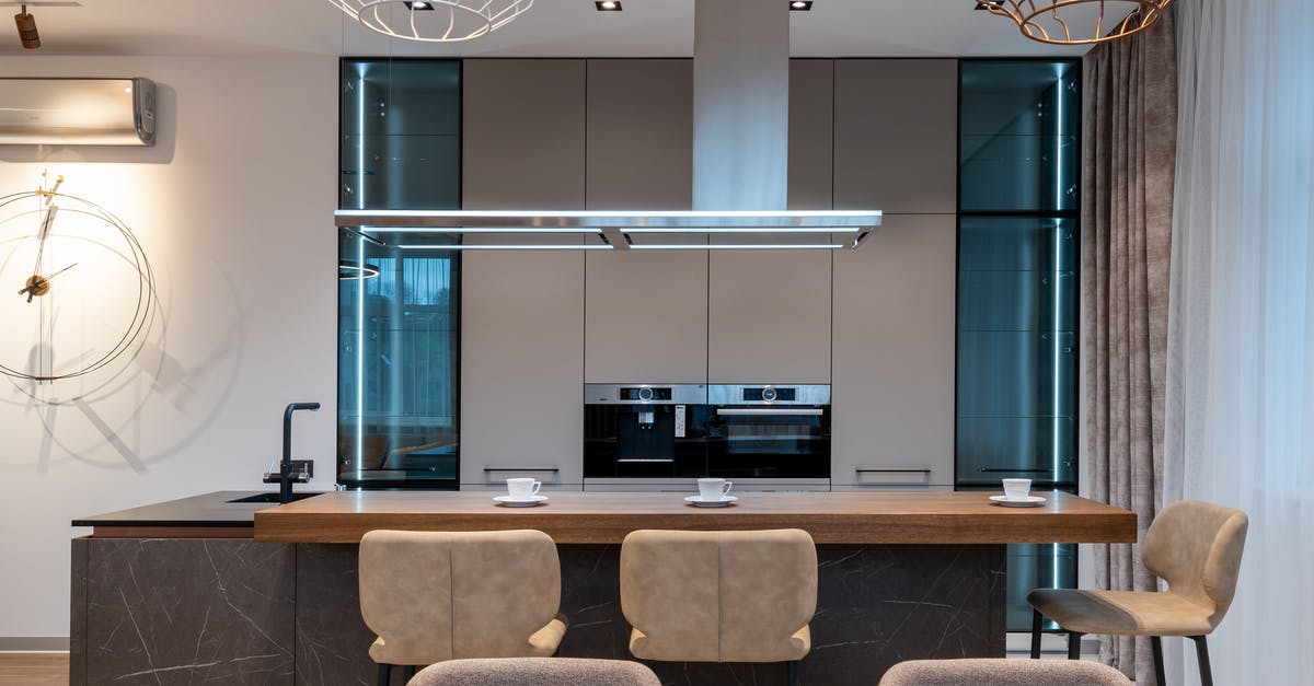 Is there an alternative and less toxic way to clean an oven than using oven spray? - Interior of room with kitchenware and counter with coffee cups near table and chairs with cabinet and oven near curtains and sink