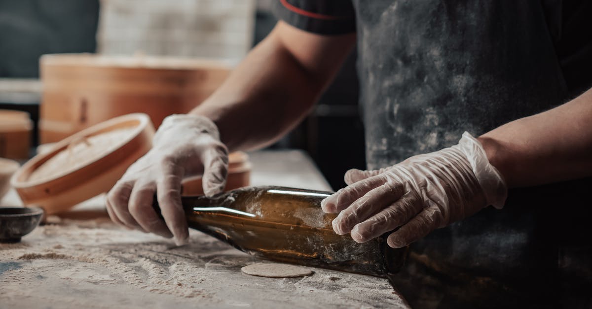 Is there an alternative to spreading flour when rolling the dough? - A Person Holding a Glass Bottle Is there an alternative to spreading flour when rolling the dough? - A Person Holding a Glass Bottle