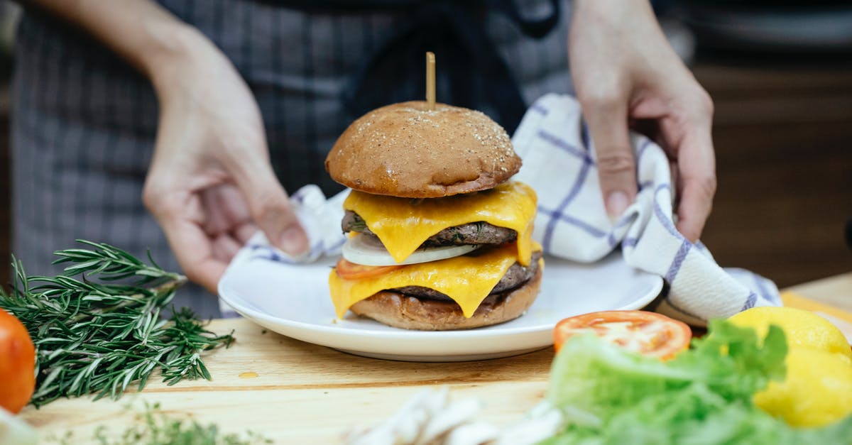 Is there an application for soft cheese rinds? - Faceless cook with tasty cheeseburger on plate at home Is there an application for soft cheese rinds? - Faceless cook with tasty cheeseburger on plate at home