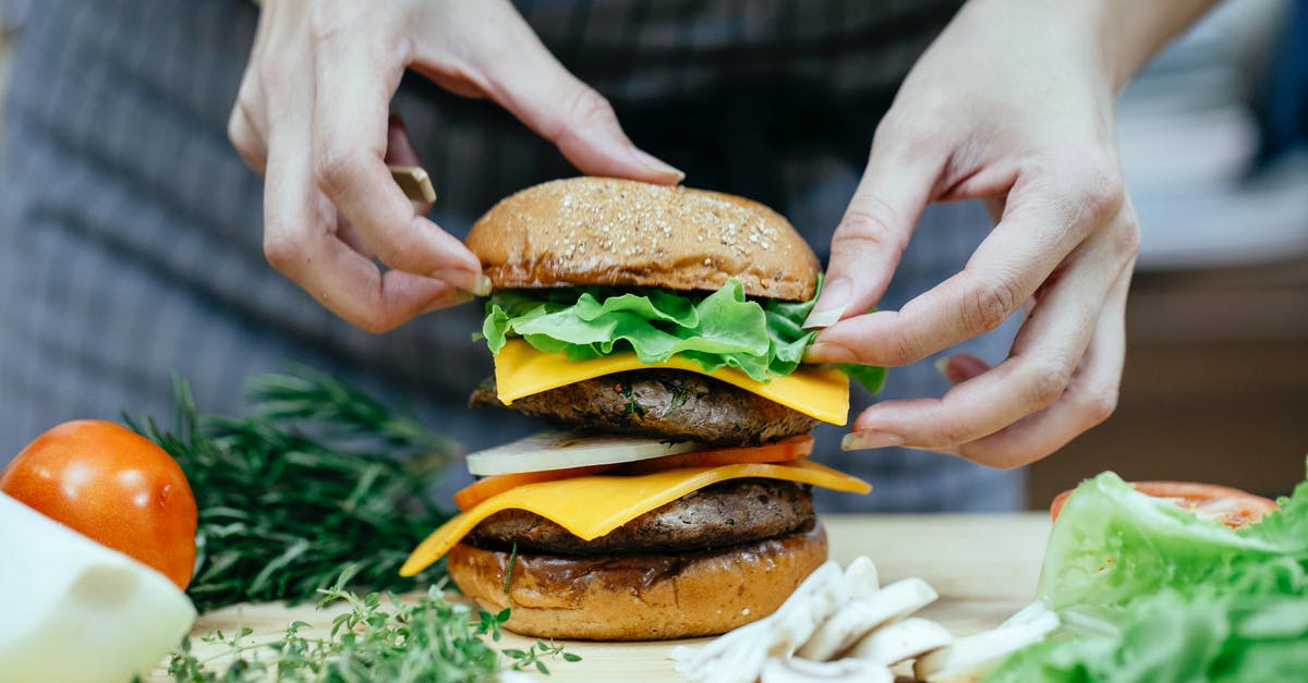 Is there an application for soft cheese rinds? - Crop anonymous female cook putting soft bread bun on top of lettuce leaves and meat patty while preparing double cheeseburger in kitchen Is there an application for soft cheese rinds? - Crop anonymous female cook putting soft bread bun on top of lettuce leaves and meat patty while preparing double cheeseburger in kitchen