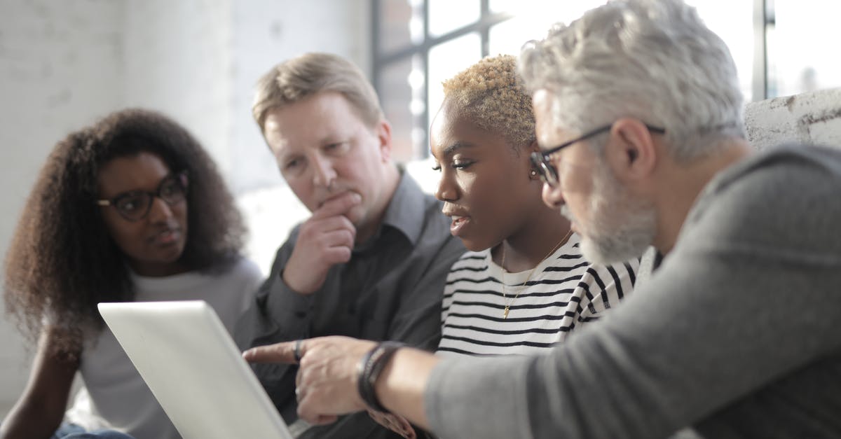 Is there any point in considering sous vide for unskilled newbie cook? - Middle aged employee in eyeglasses pointing at netbook screen with finger while sitting near multiracial pensive colleagues near window in afternoon
