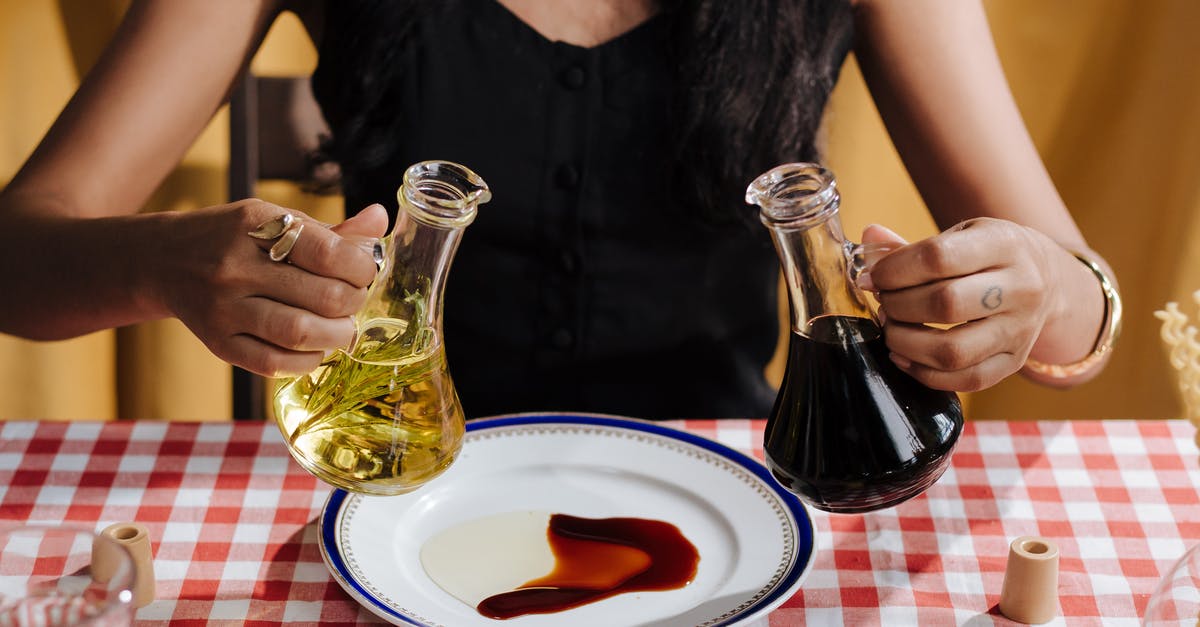 Is there anything wrong with keeping oil, salt, and vinegar together? [duplicate] - Woman with Olive Oil and Vinegar Bottles in Hands