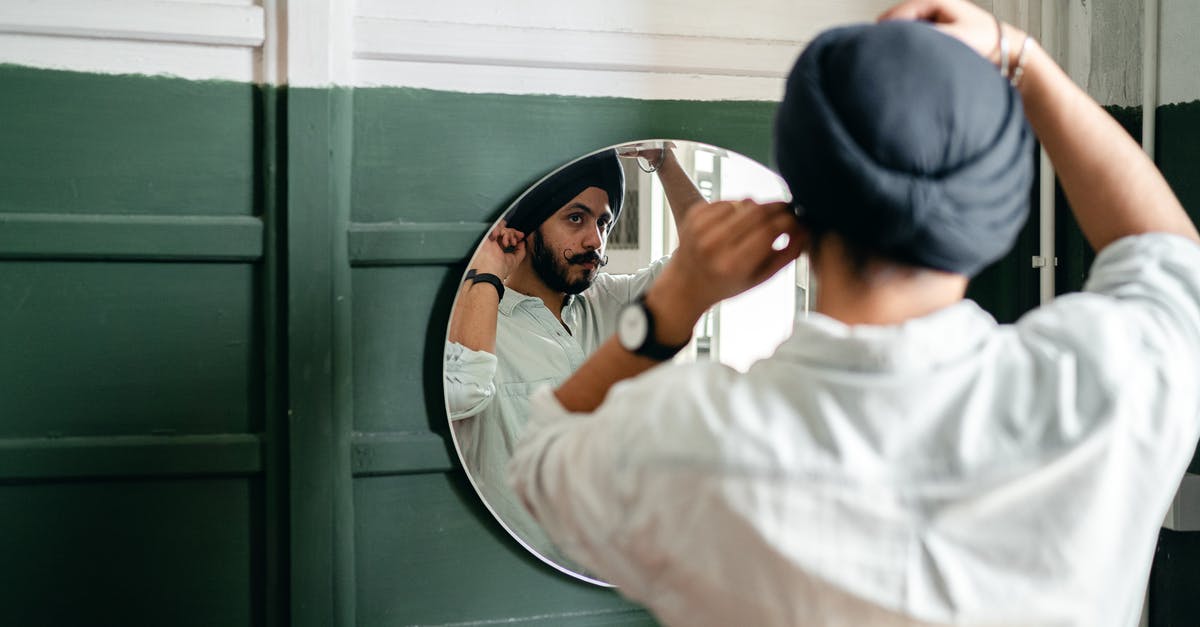 Is there cultural variations on what is consider offal? - Young ethnic man looking of mirror at home Is there cultural variations on what is consider offal? - Young ethnic man looking of mirror at home